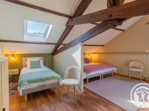 a attic bedroom with two beds and a window at Gîte spacieux de 8 chambres au cœur des vignes d'Anjou - FR-1-622-112 in Saint-Sulpice