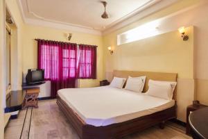 a bedroom with a large bed and a tv at Hotel Sun Rock in Kanyakumari