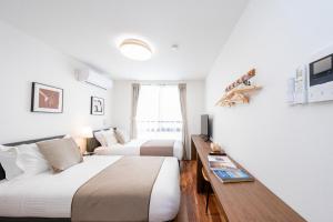a hotel room with two beds and a table at 銀座線徒歩9分 松が谷アパート in Tokyo