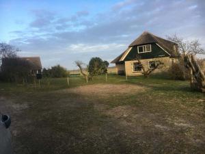 a house in a field with a grass yard at Holiday home in Hollum with barbecue in Hollum