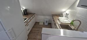een kleine keuken met een spoelbak en een aanrecht bij Rozmaring Apartman Csopak in Csopak