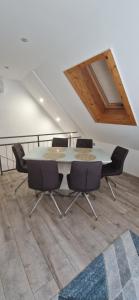 een tafel en stoelen in een kamer met een plafond bij Rozmaring Apartman Csopak in Csopak +9 foto's