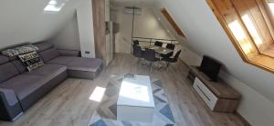 een woonkamer met een bank en een tafel bij Rozmaring Apartman Csopak in Csopak