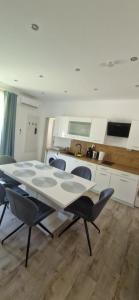 een keuken met een tafel en stoelen in een kamer bij Rozmaring Apartman Csopak in Csopak