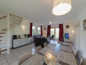 a dining room and living room with a table and chairs at Holiday Home in Quiet Dutch Park for Families in Wemeldinge
