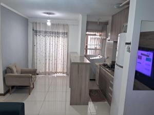 a kitchen with a refrigerator and a couch in a room at Apartamento próximo ao centro e Havan in Gravataí +1 photo