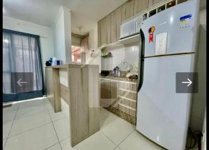 a kitchen with a white refrigerator and a counter at Apartamento próximo ao centro e Havan in Gravataí