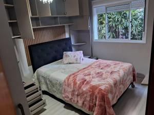 a bedroom with a bed and a window at Apartamento próximo ao centro e Havan in Gravataí