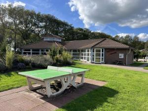 a picnic table in front of a house at Holiday home with 2 bedrooms in Zwiggelte