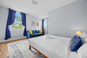 a bedroom with a bed and a blue couch at Newly-renovated Stylish Home in Louisville KY in Louisville