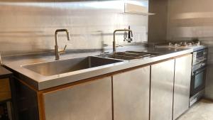 una cocina con fregadero y estufa en ふくぎリビング - Fukugi Living, en Motobu 7 fotos más
