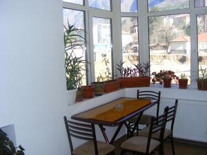 a table and chairs in a room with windows at Pensiunea Argus in Băile Herculane