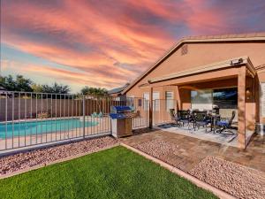 a house with a pool and a patio with a table at Kimberly Surprise in Surprise