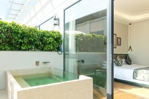una doccia in vetro in una camera da letto di Vishan Garden Boutique Hotel 厦门维尚花园潮宿 中山路步行街店 a Xiamen