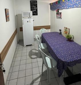 cocina con mesa púrpura y nevera en kit net básico centro 1, en Campina Grande