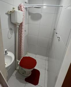 Un baño con un inodoro rojo y un lavabo. en kit net básico centro 1, en Campina Grande