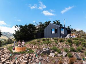 a black tiny house on top of a hill at Kūkupa Matairangi at Akaroa Lavender in Akaroa