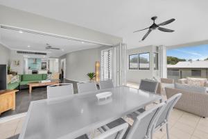 una sala da pranzo e un soggiorno con tavolo e sedie di Turquesa Tides - Beachfront Resort Living a Palm Cove