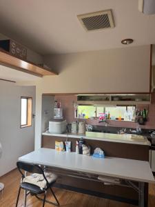 a kitchen with a table and a counter top at 我孫子ハウス in Abiko