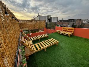 a rooftop garden with benches on a roof at Olespier Hostel in Arequipa