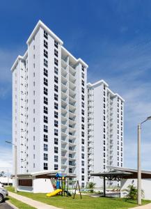 un gran edificio blanco con un parque infantil delante de él en Viva Jaco, en Jacó