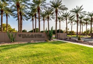 a sign in a park with palm trees at Palmen Maricopa in Maricopa