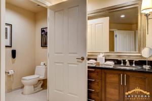 a bathroom with a toilet and a sink and a mirror at MGM Signature-03-611 Strip View Jacuzzi Studio in Las Vegas