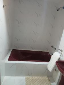a red bath tub in a bathroom with a sink at Misha House in Huaraz