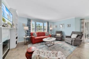 a living room with a red couch and a table at Updated, Ground Floor Unit w/ Pool & Gym, Sleeps 6 in Gulf Shores