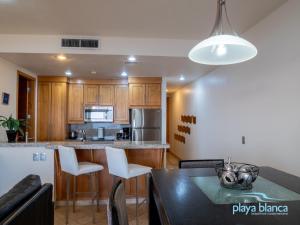 a kitchen with a table and white chairs in a room at Playa Blanca Premier Unit 1407 in San Carlos