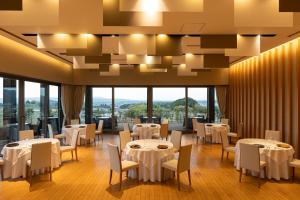 a restaurant with white tables and chairs and large windows at AUBERGE de SENVIE in Sakurai