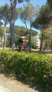 a group of trees and a playground in a park at Affittacamere Il Conte in Follonica