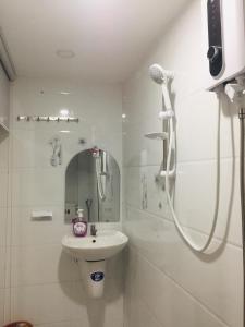 a white bathroom with a sink and a shower at Yến Homestay in Phước Hậu