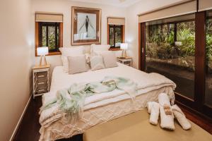 a bedroom with a large bed with towels on the floor at Port Douglas Alamanda Estate w Ocean Views & Pool in Craiglie +15 photos