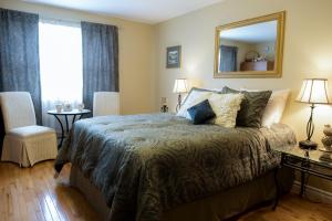 a bedroom with a bed and a mirror and a window at Serene Suites in Halifax