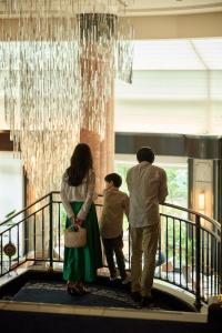 a family walking down a stairway under a chandelier at The Westin Tokyo in Tokyo