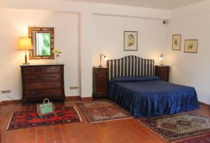 a bedroom with a bed and a dresser and a mirror at Villa San Bartolomeo in San Gregorio di Catania