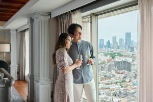 a man and a woman standing in front of a window at The Westin Tokyo in Tokyo