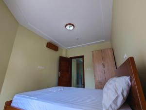 a bedroom with a bed with a light on the ceiling at Résidence Romacy, appartement 2 chambres avec balcon à Ahala, quartier résidentiel de Yaoundé in Yaoundé
