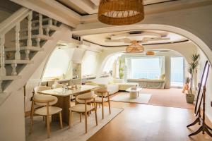 sala de estar con arco, mesa y sillas en Double-decker pension Ocean view duplex with a view of Cheongsapo Beach train #High-rise view#Ocean front view, en Busan