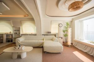 una sala de estar con un sofá y una mesa en Double-decker pension Ocean view duplex with a view of Cheongsapo Beach train #High-rise view#Ocean front view, en Busan