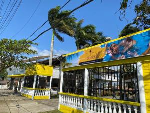 a yellow and white building with a billboard on it at Hotel Purobeach in Turbo