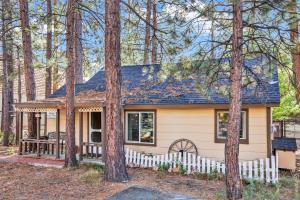 a small house with a white fence in the woods at Pines 23 #1438 in Big Bear Lake +4 photos