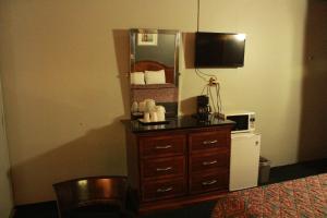 a room with a dresser with a microwave and a mirror at Budget Inn -Yreka in Yreka