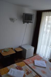 a living room with a tv on the wall at Pensiunea Argus in Băile Herculane