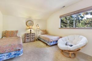 ein Schlafzimmer mit einem Bett und einem Stuhl und einem Fenster in der Unterkunft Tree top views #2060 in Big Bear Lake