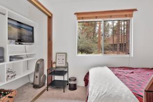 een slaapkamer met een bed, een tv en een raam bij Casa bosque #2176 in Big Bear Lake