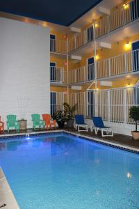a large swimming pool in a hotel room with chairs at Seaside Inn & Suites in Fenwick Island