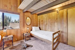 ein Schlafzimmer mit einem Bett in einem Zimmer mit einem Fenster in der Unterkunft Golf & Ski Retreat #1443 in Big Bear Lake