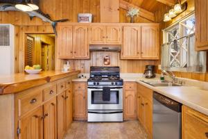 eine Küche mit Holzschränken und einem Herd in der Unterkunft Oriole cottage #621 in Big Bear Lake + 9 Fotos